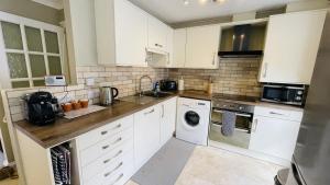 a kitchen with white cabinets and white appliances at Old Quay House - Views of Coronation Park and River Dart in Dartmouth