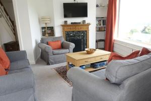 a living room with two chairs and a fireplace at Pipiriki - Spectacular views and outstanding garden in peaceful location in Dittisham