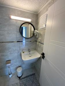 a bathroom with a sink and a mirror at ATICI HOTEL in Antalya