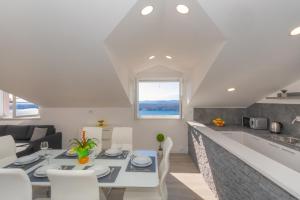 een keuken en een woonkamer met een tafel en stoelen bij Apartment Exclusive VIEW in Šibenik