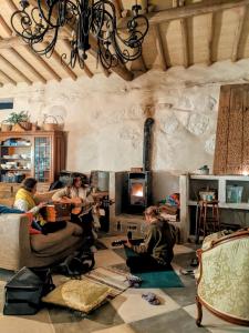 a group of people sitting in a living room playing music at Wild Oasis - Algarve in Monchique