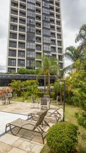 a group of picnic tables and chairs in front of a tall building at Plaza Inn Small Town Flat in Sao Paulo