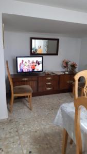 a living room with a flat screen tv on a entertainment center at Casa de Pueblo ,Sauca in Saúca