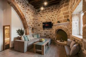 a living room with a couch and a stone wall at Villa Gemma in Haraki