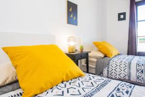 a bedroom with two beds with yellow sheets and a table at Eslanzarote Acoruma House, Super Wifi, Heated Pool in Güime