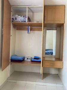 Armario con estanterías de madera y espejo en Joshua’s place: cosy furnished one bedroom apt, en Meru
