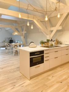 een keuken met witte kasten en een fornuis met oven bij SOLÉY in Sohland am Rotstein