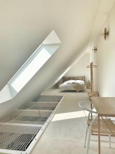 een witte zolderslaapkamer met een bed onder de trap bij SOLÉY in Sohland am Rotstein