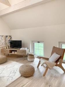 een woonkamer met een stoel en een televisie bij SOLÉY in Sohland am Rotstein