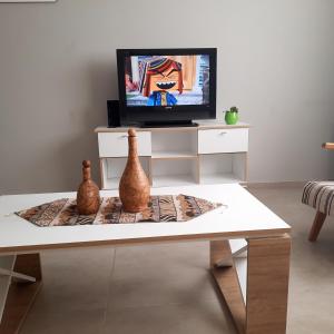 sala de estar con mesa y TV en APART VITTA en Río Cuarto