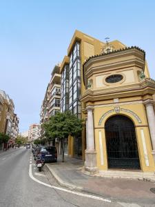 un bâtiment jaune sur le côté d'une rue dans l'établissement Balcón Victoria, à Malaga