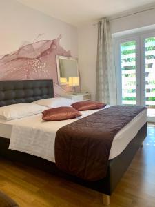 a bedroom with a large bed with two pillows on it at Apartments Zicara in Dubrovnik
