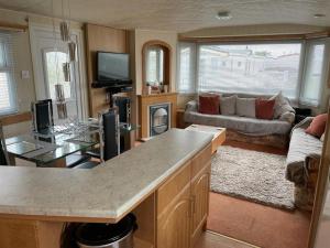 a kitchen and living room with a couch and a table at Southfield 97 in Great Driffield