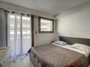 カンヌにあるMajestic Apartmentのベッドルーム(大型ベッド1台、窓付)