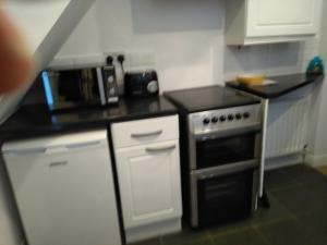 a small kitchen with a stove and a microwave at Apartment with Outside Patio and Car Space in Durham