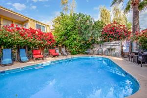 a swimming pool in a yard with chairs and flowers at Desert Rose Villas - Spotless Three Bedroom Villa in the Heart of Scottsdale in Scottsdale
