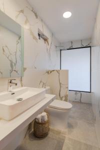 a bathroom with a sink and a toilet and a mirror at Hotel Villa Camila in La Pintada