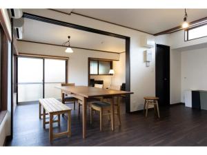 a dining room with a wooden table and chairs at Halettohouse SAKANOSHITA - Vacation STAY 30106v in Kamakura