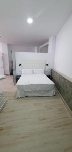 una camera con letto bianco e pavimento in legno di LOFT APARTAMENTo a San José de la Rinconada