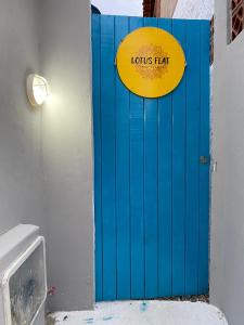 Una puerta azul con una señal amarilla. en Lotus Flat - Canoa Quebrada en Aracati