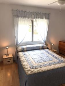 une chambre avec un grand lit avec une fenêtre dans l'établissement Apartamento a 100m de la Cala Blanca, à Jávea