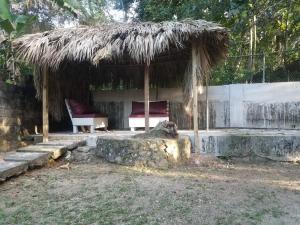 une cabane avec un banc et une chaise dans l'établissement Unity Villa 3 bedroom with fans Wifi Parking, à Montego Bay