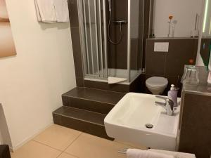 W łazience znajduje się umywalka, prysznic i toaleta. w obiekcie Hotel Restaurant Latio w Kolonii