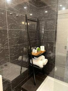 bagno piastrellato nero con specchio e doccia di Luxury apartment in center Cascais a Cascais