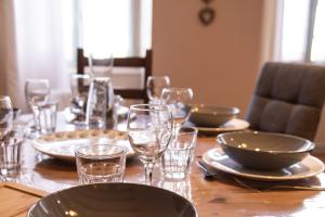 una mesa de madera con platos y vasos. en Havre Urbain Furnished flat, en Annecy