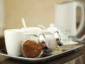 um recipiente de grãos de café numa bandeja com chávenas em The Liver View em Birkenhead
