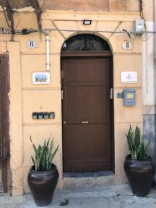 dos macetas sentadas frente a un garaje en La Piccola Formica Charme Rooms, en Palermo