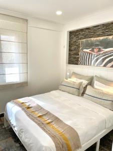 un letto bianco in una camera da letto con un dipinto sul muro di Luxury apartment in center Cascais a Cascais