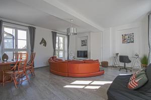 uma sala de estar com um sofá laranja no meio em La Promesse BAYEUX Free Car Park em Bayeux