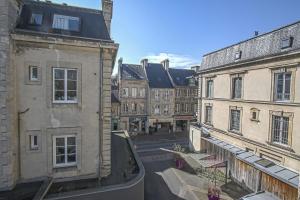 uma rua vazia numa cidade com edifícios em La Promesse BAYEUX Free Car Park em Bayeux