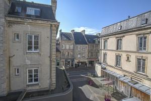 an empty street in a city with buildings at La Promesse BAYEUX Free Car Park in Bayeux