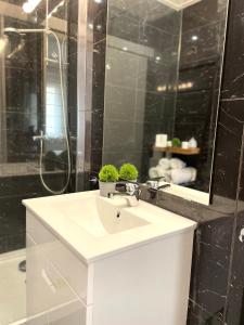 bagno con lavandino bianco e specchio di Luxury apartment in center Cascais a Cascais