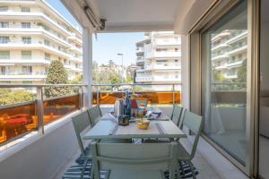 a table and chairs on a balcony with a view at SERRENDY 2-bedroom apartment near Croisette in Cannes