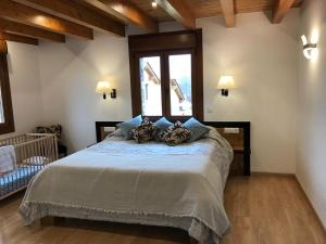 a bedroom with a large bed with blue pillows at Maison Cerdagne in Bourg-Madame