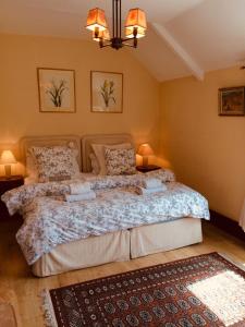 - une chambre avec un grand lit, deux lampes et un tapis dans l'établissement Le Clos Rabelais, à Langeais