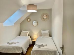 2 camas en una habitación con 2 espejos en Émeraude Lumineux T3 au cœur du village, à 5 min des plages, en Saint-Méloir-des-Ondes