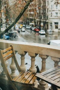 a wooden chair on a balcony with a view of a street at Bailén Green House in Barcelona