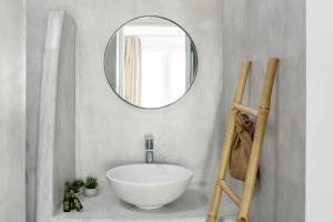 a bathroom with a white sink and a mirror at Cal Day Rooms Santorini in Perissa
