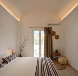 a bedroom with a large white bed and a window at Cal Day Rooms Santorini in Perissa