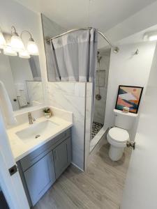 a bathroom with a sink and a shower and a toilet at Hawaiian Monarch 1804 condo in Honolulu