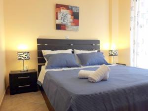 1 dormitorio con 1 cama azul grande y 2 lámparas en Sophie's Sweet Home, en Perdika