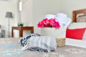 un cesto con asciugamani e fiori su un tavolo di Les jardins de CHANTILLY -Bungalows 4 étoiles avec jardins et piscines privées a Baie-Mahault