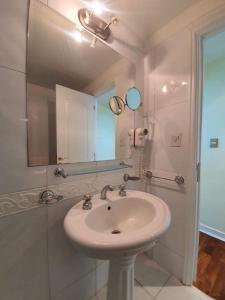 uma casa de banho com um lavatório e um espelho em Mendoza Premium Suites - Dpto de Lujo Piso 14 - Vista A La Montaña! em Mendoza