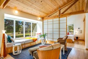 un salon avec un lit et une grande fenêtre dans l'établissement Madrone Cottage, à Sea Ranch