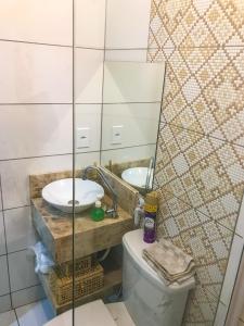 een badkamer met een wastafel, een toilet en een spiegel bij Casa No Centro Histórico in Logradouro