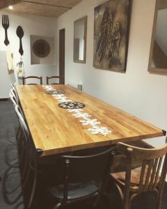 una mesa de madera en una habitación con sillas alrededor en Hameau des deux ailes en Précigné